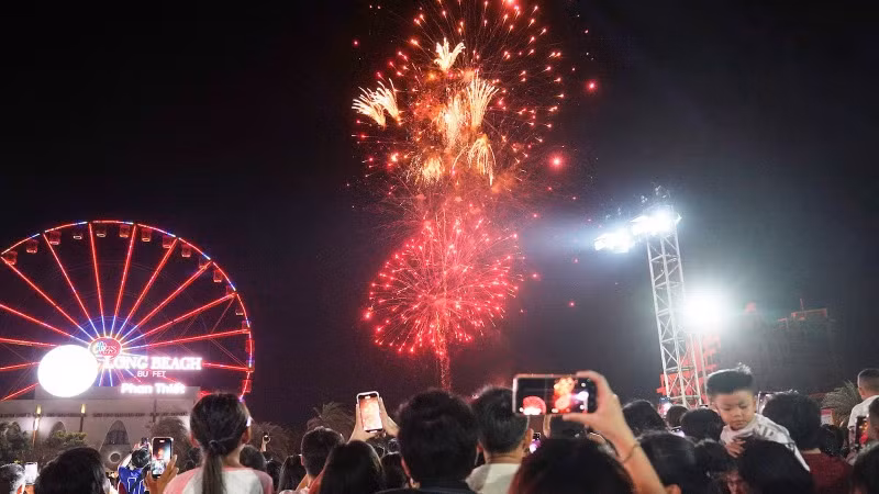 Du khách xem bắn pháo hoa.