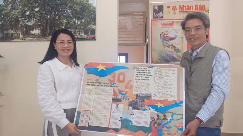 Chị Hồ Lan hạnh phúc khi cầm phụ san 30/4 Báo Nhân Dân trên tay.