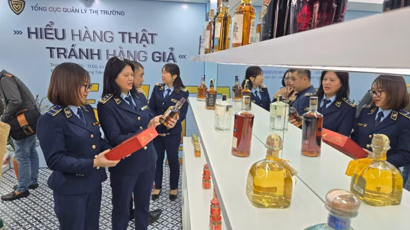 Cán bộ Tổng cục Quản lý thị trường hướng dẫn dấu hiệu nhận diện hàng hóa thật-giả. 