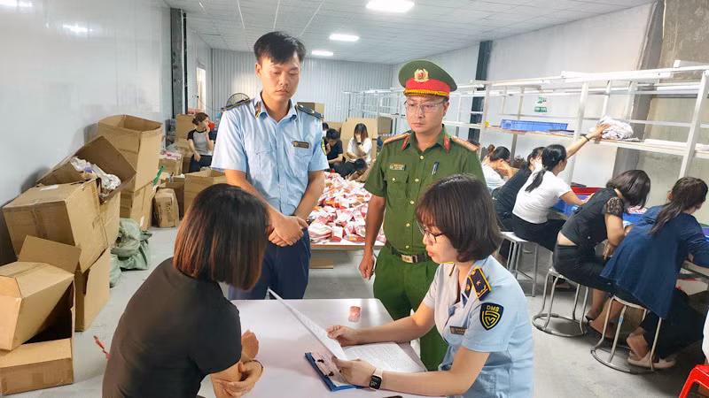 Lực lượng Quản lý thị trường phối hợp với lực lượng Công an kiểm tra một kho hàng vi phạm