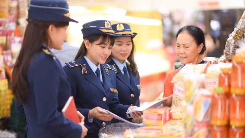 Công chức Quản lý thị trường hướng dẫn các hộ kinh doanh chấp hành quy định pháp luật về kinh doanh, buôn bán.