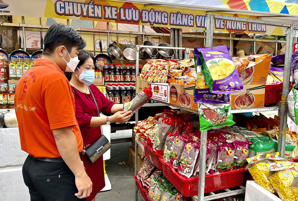 Mua sắm tại chuyến xe lưu động đưa hàng Việt về nông thôn ở huyện Châu Thành, tỉnh An Giang. (Ảnh THANH SANG)