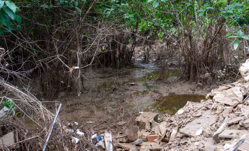 Một đoạn kênh bị bồi lấp nặng nề bởi bùn đất và xà bần.