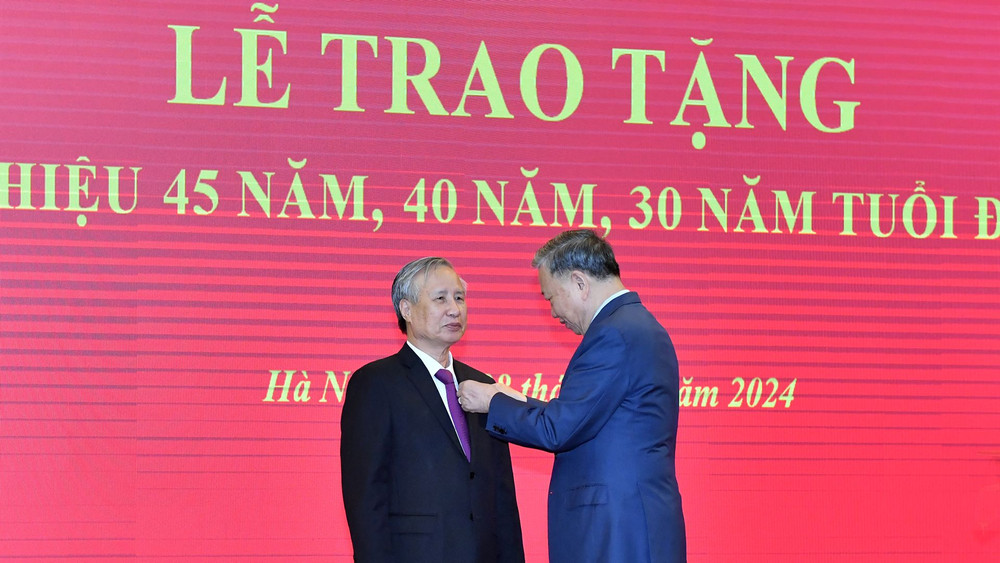 Tổng Bí thư Tô Lâm gắn Huy hiệu 45 năm tuổi đảng tặng đồng chí Trần Quốc Vượng. (Ảnh: ĐĂNG KHOA)