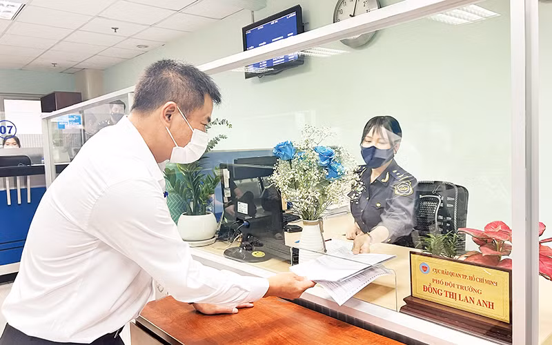 Cán bộ Hải quan Thành phố Hồ Chí Minh hướng dẫn thủ tục khai thuế cho doanh nghiệp. (Ảnh Cục Hải quan thành phố)