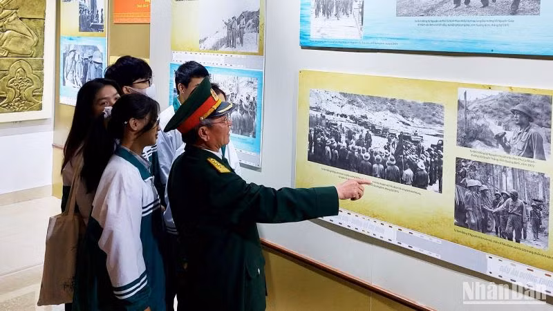 Các bạn trẻ nghe giới thiệu ảnh về Trung tướng Đồng Sỹ Nguyên trong những ngày ở tuyến lửa Trường Sơn.