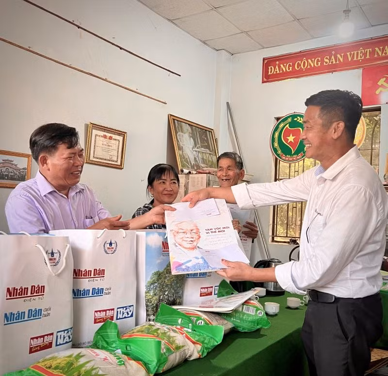Đại diện Văn phòng Báo Nhân Dân tại Bình Phước tặng quà cho các gia đình có công với cách mạng tại xã Phước An, huyện Hớn Quản.