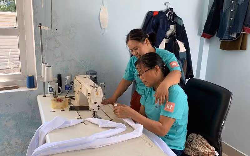 Cô Thanh (ngồi) tỉ mỉ hướng dẫn Linh gấp nếp vải.