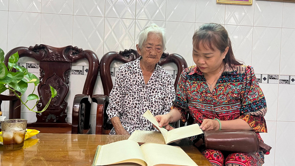 Cụ Võ Thị Quỳnh Mai cùng con gái xem kỷ vật của chồng, ba để lại.