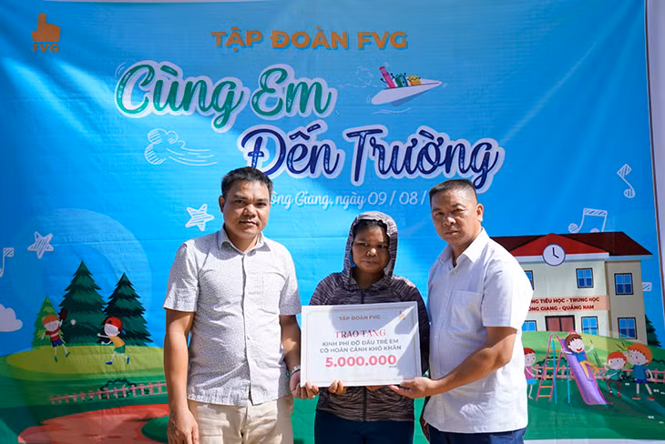 Phụ huynh em A Lăng Thị Bít, thôn Bến Hiên, xã Kà Dăng (huyện Đông Giang) nhận học bổng do Tập đoàn FVG trao tặng.