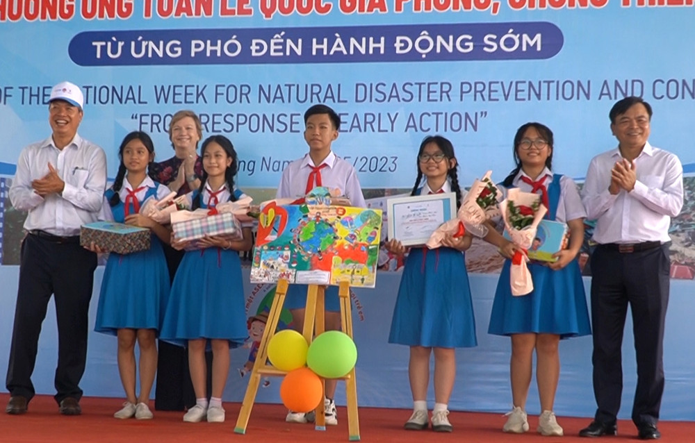 Đại biểu trao quà tặng học sinh đoạt giải các cuộc thi hưởng ứng chống thiên tai.