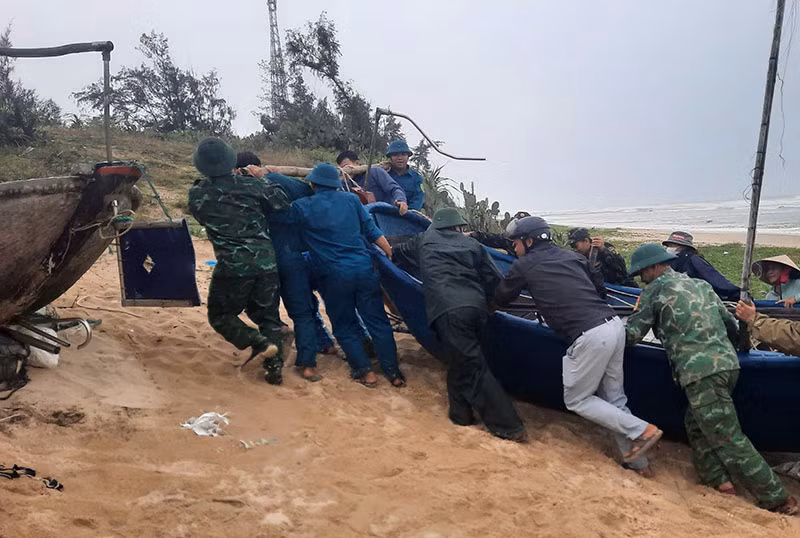 Các lực lượng vũ trang huyện Thăng Bình khẩn trương giúp ngư dân đưa tàu thuyền vào bờ an toàn.