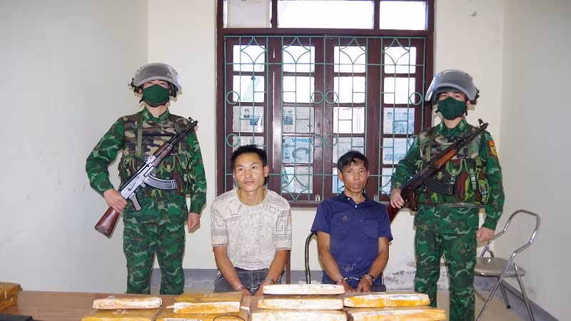 Hai đối tượng gồm: Mùa A Nhà, Mùa A Pha cùng tang vật khi bị bắt. (Ảnh: ANH DŨNG)