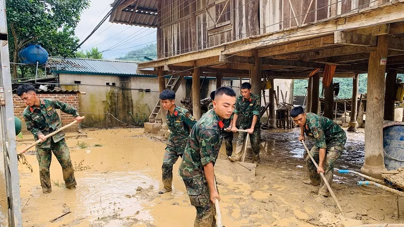 Chiến sĩ các đơn vị thuộc Bộ Chỉ huy quân sự tỉnh Điện Biên giúp người dân xã Mường Pồn thu dọn nhà cửa, dọn dẹp vệ sinh ổn định cuộc sống sau lũ quét. 
