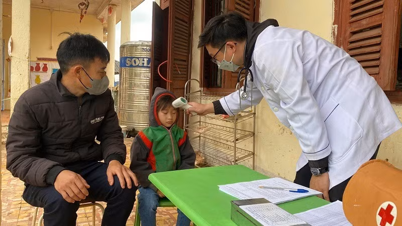 Cán bộ Trung tâm Y tế huyện Nậm Pồ khám sàng lọc trước lúc tiêm vaccine phòng bệnh sởi cho trẻ em trên địa bàn huyện. 