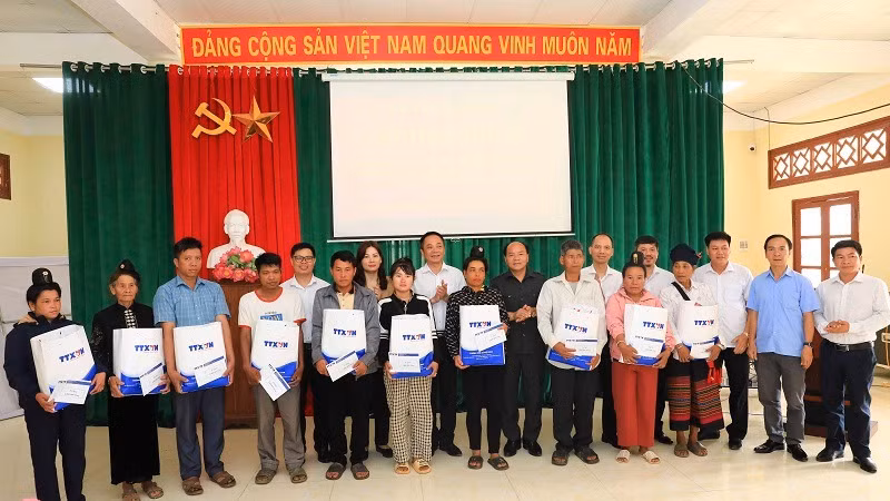 Các đồng chí trong đoàn công tác Thông tấn xã Việt Nam và ông Đào Hoài Nam, Phó Chủ tịch Ủy ban nhân dân thành phố Điện Biên Phủ, trao quà đến các gia đình nghèo.