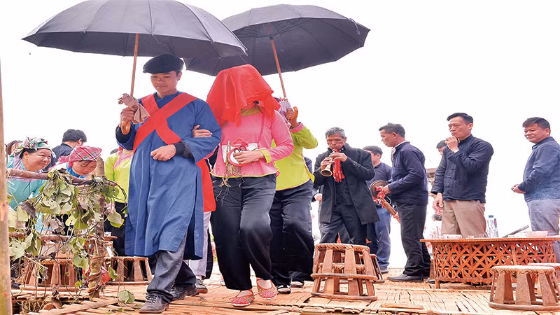 Cô dâu được trùm khăn đỏ trước khi về nhà chồng. Cô dâu được trùm khăn đỏ trước khi về nhà chồng.