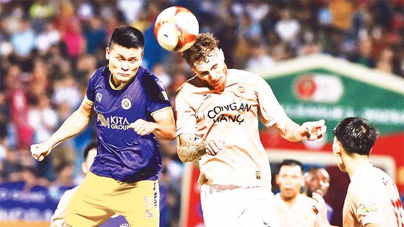 Pha tranh bóng giữa cầu thủ đội Công an Hà Nội (bên phải) với cầu thủ đội Hà Nội FC. (Ảnh TRẦN HẢI) 