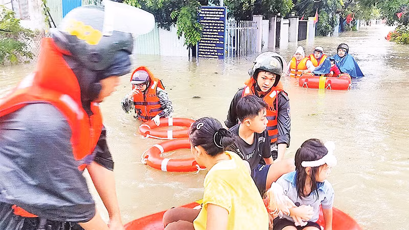 Cảnh sát cơ động Công an thành phố Ðà Nẵng di dời người dân Tổ 129, phường Hòa Minh, quận Liên Chiểu đi tránh lũ sáng 14/10. 