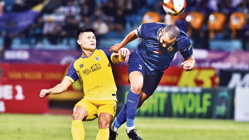 Hà Nội FC (áo vàng) thua MerryLand Quy Nhơn Bình Ðịnh trên sân nhà. (Ảnh TRẦN HẢI) 