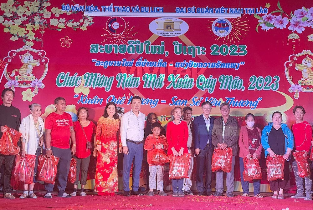 Ban Tổ chức trao quà cho kiều bào có hoàn cảnh khó khăn. (Ảnh: Hải Tiến)