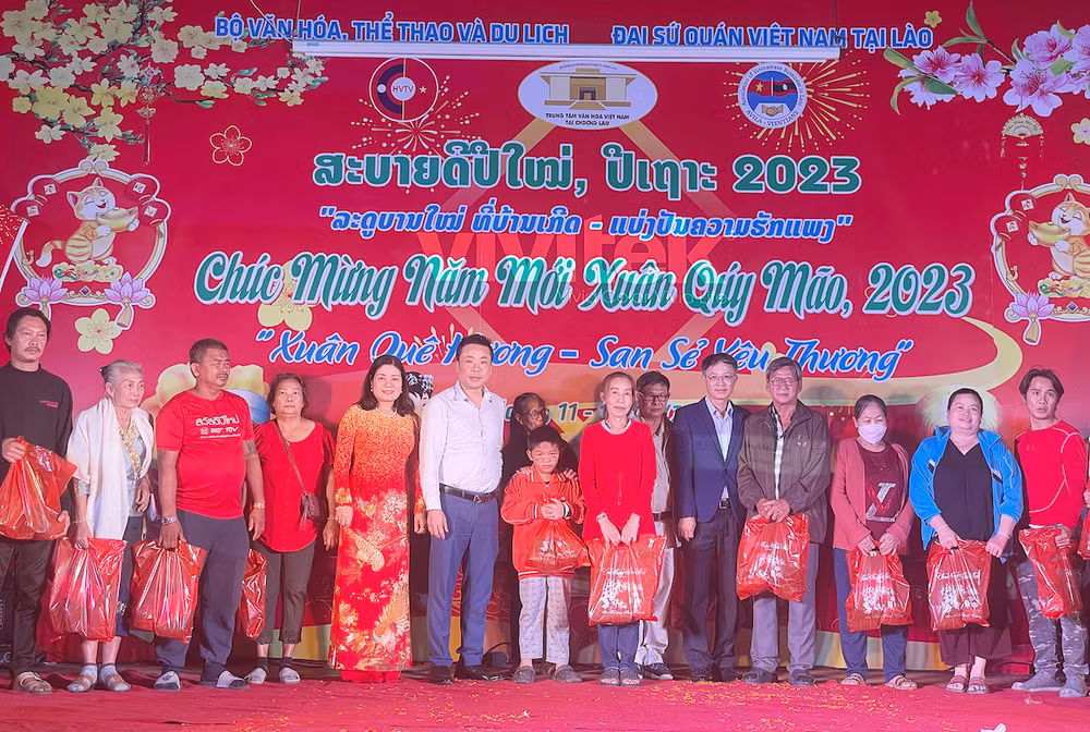 Ban Tổ chức trao quà cho kiều bào có hoàn cảnh khó khăn. (Ảnh: Hải Tiến)