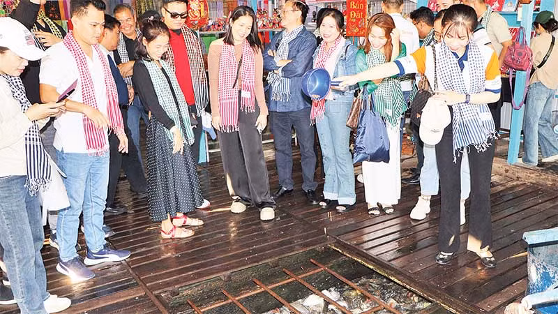 Du khách thích thú cho cá ăn tại Làng bè sắc mầu ngã ba sông Châu Đốc.