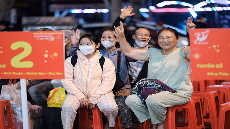 Người dân vui mừng trước khi lên “Chuyến xe hạnh phúc” để về quê đón Tết.