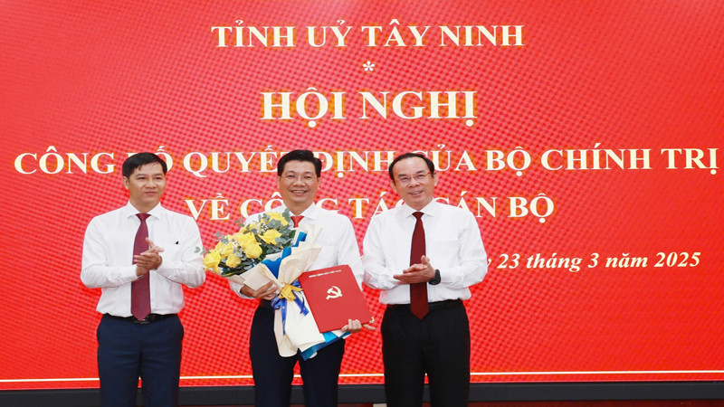 Đồng chí Nguyễn Văn Nên, Ủy viên Bộ Chính trị, Bí thư Thành ủy Thành phố Hồ Chí Minh (phải) và đồng chí Nguyễn Thành Tâm, Ủy viên Trung ương Đảng, Phó Trưởng ban Tổ chức Trung ương, trao quyết định, tặng hoa chúc mừng đồng chí Nguyễn Mạnh Hùng.