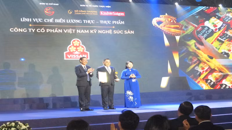 Đồng chí Phan Văn Mãi (bên trái) trao giải thưởng cho một doanh nghiệp.