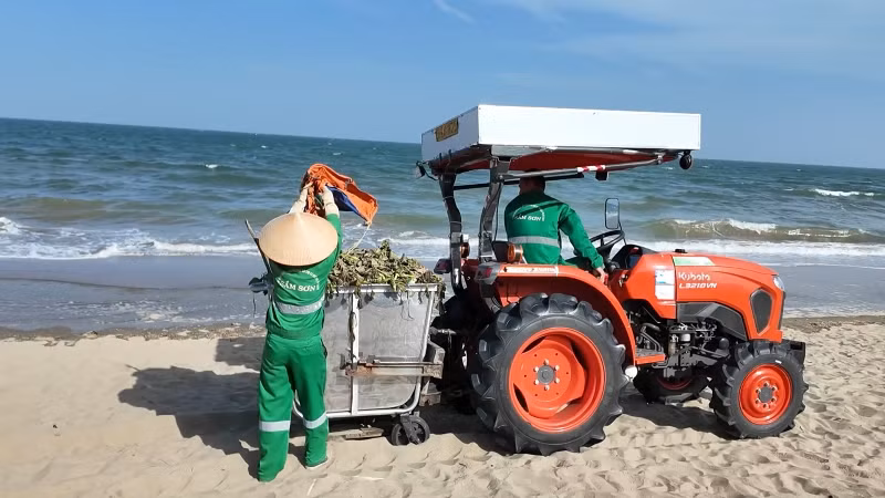 Công nhân môi trường thu gom rác trên bãi biển.