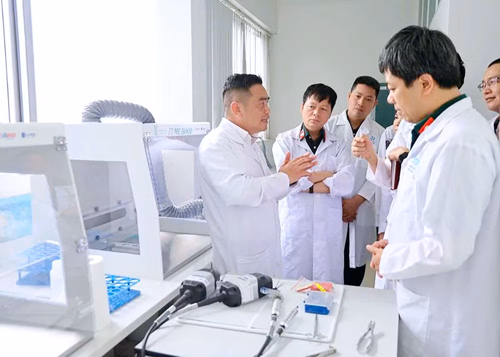 C&aacute;n bộ Trung t&acirc;m Gi&aacute;m định ADN b&aacute;o c&aacute;o kết quả gi&aacute;m định h&agrave;i cốt liệt sĩ với c&aacute;c đồng ch&iacute; l&atilde;nh đạo.