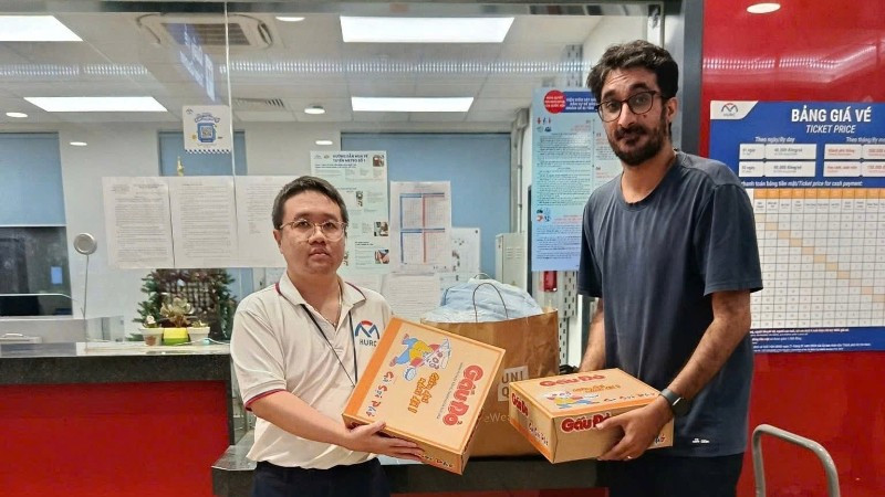 Người nước ngoài mang hàng cứu trợ người dân vùng lũ đến ga Metro kết hợp di chuyển bằng Metro. (Ảnh: VÕ LÊ)