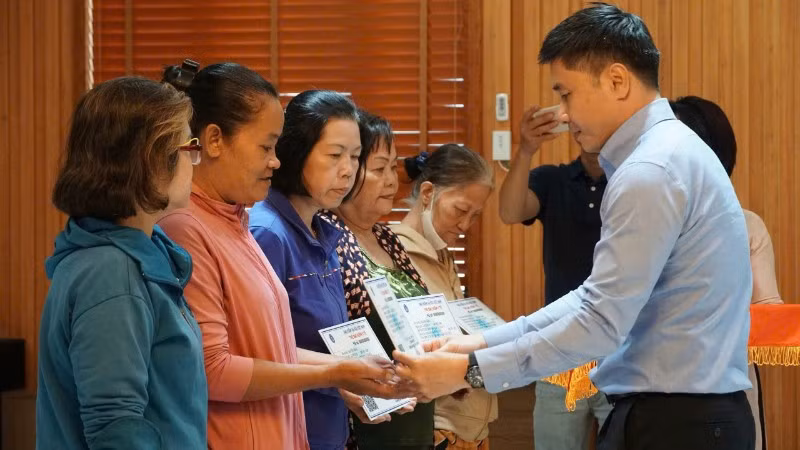 Lãnh đạo Cơ quan Bảo hiểm xã hội Thành phố Hồ Chí Minh tặng thẻ Bảo hiểm y tế cho phụ nữ có hoàn cảnh khó khăn. (Ảnh: VÕ LÊ)