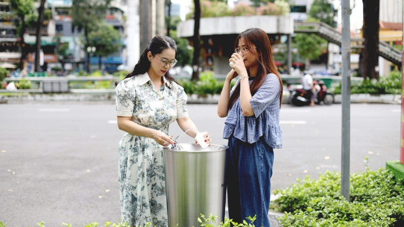 Các bạn trẻ sử dụng trụ nước uống tại vòi đặt ở Khu vực Hồ Con Rùa. (Ảnh: QUÝ HIỀN)