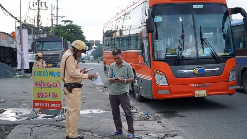 Lực lượng Công an kiểm tra chủ phương tiện xe khách tuyến đường dài. (Ảnh: QUÝ HIỀN)