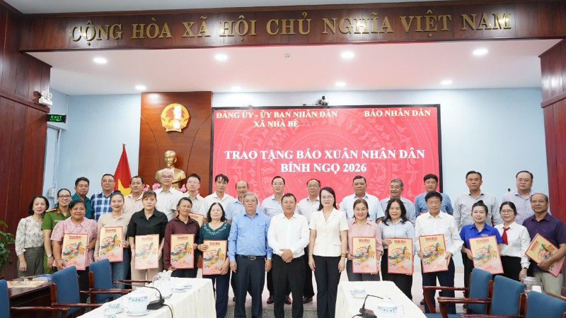 Cơ quan Đại diện Báo Nhân Dân tại khu vực miền Nam cùng Hội đồng nhân dân, Ủy ban nhân dân xã Nhà Bè trao tặng báo Xuân Nhân Dân Bính Ngọ 2026 tại xã Nhà Bè. (Ảnh: KIM NGỌC)