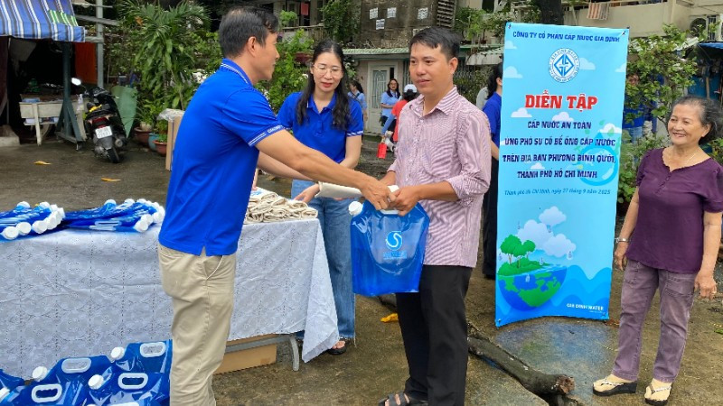 Công ty Cổ phần Cấp nước Gia Định cùng người dân diễn tập cấp nước an toàn nhằm ứng phó sự cố bể ống cấp nước tại lô I, II cư xá Thanh Đá, phường Bình Quới. (Ảnh: QUÝ HIỀN)