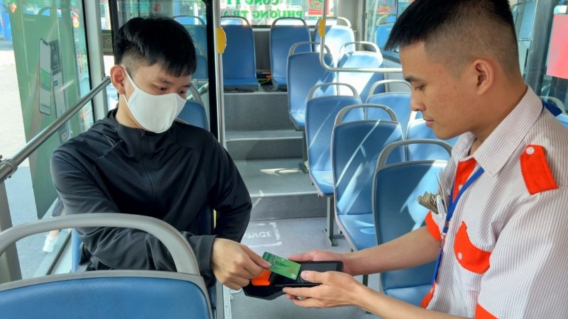 Hành khách thanh toán không dùng tiền mặt khi đi một số tuyến xe buýt của thành phố. (Ảnh: QUÝ HIỀN)