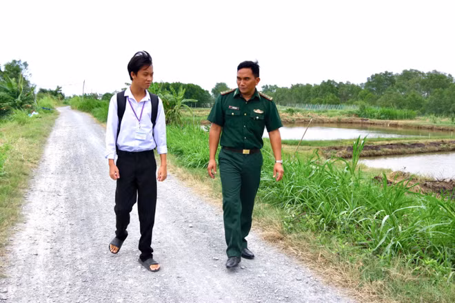 Con nuôi Phạm Văn Giàu chia sẻ ước mơ về con đường học tập cùng Thượng úy Thạch Minh Sỹ. (Ảnh: LÊ KHOA)