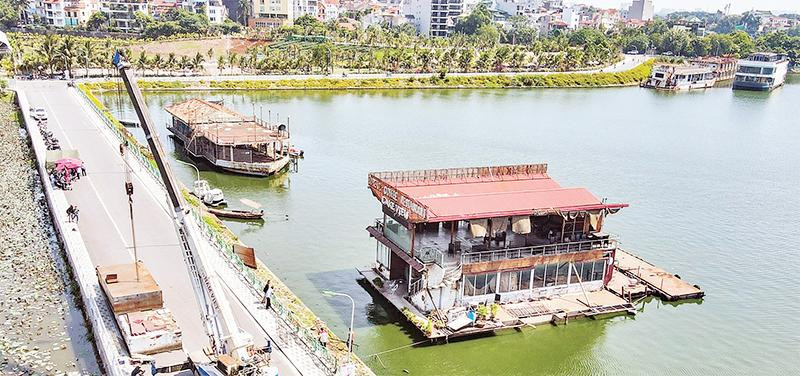Tổ công tác liên ngành quận Tây Hồ tiến hành tháo dỡ những chiếc du thuyền bỏ hoang trên hồ Tây từ nhiều năm nay. (Ảnh HOÀNG HẢI)