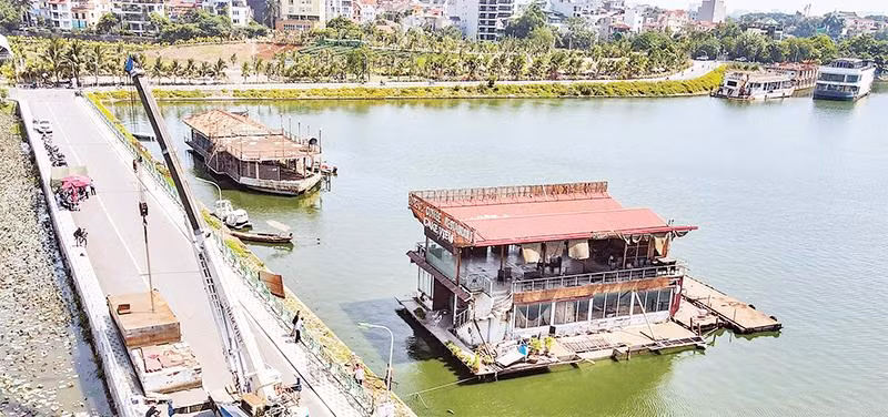 Tổ công tác liên ngành quận Tây Hồ tiến hành tháo dỡ những chiếc du thuyền bỏ hoang trên hồ Tây từ nhiều năm nay. (Ảnh HOÀNG HẢI)