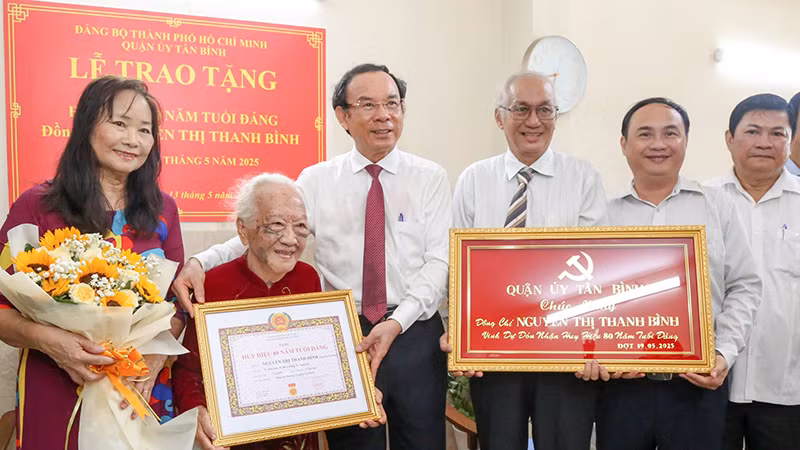 Đồng chí Nguyễn Văn Nên, Ủy viên Bộ Chính trị, Bí thư Thành ủy Thành phố Hồ Chí Minh chúc mừng Đảng viên Nguyễn Thị Thanh Bình nhận Huy hiệu 80 năm tuổi Đảng. (Ảnh L.T)