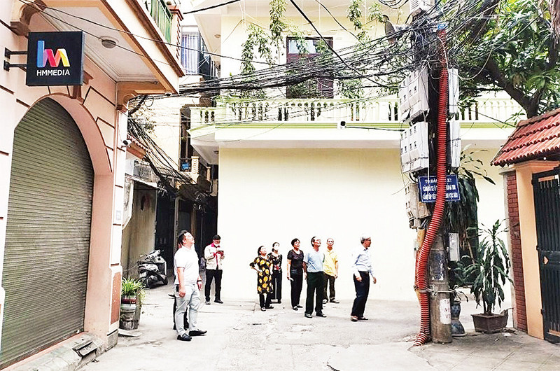 Cán bộ, người dân phường Nghĩa Đô, quận Cầu Giấy giám sát việc lắp đặt camera an ninh trên địa bàn phường. 