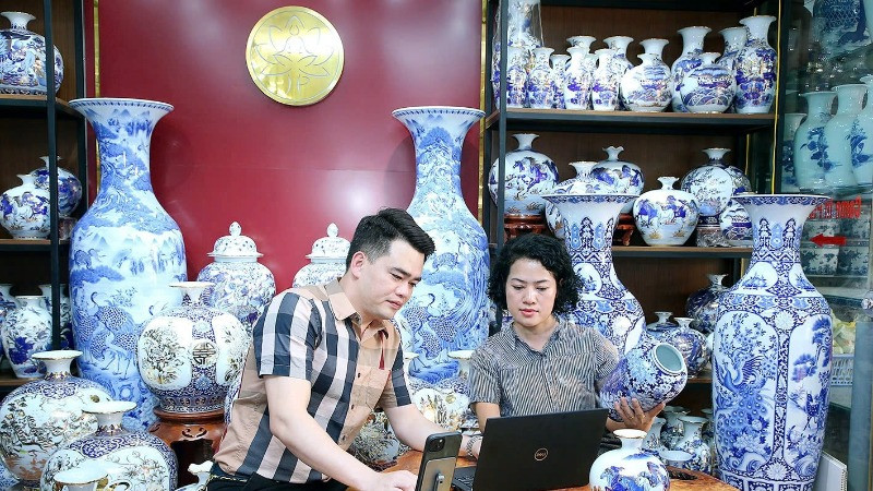 Nghệ nhân Trần Trung Hiếu (xã Bát Tràng, huyện Gia Lâm, Hà Nội) chia sẻ với đồng nghiệp về quy trình đưa sản phẩm lên sàn thương mại điện tử. (Ảnh HUY HOÀNG)