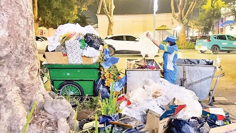 Công nhân Công ty Môi trường đô thị Hà Nội thu gom rác thải trên phố. (Ảnh: nhandan.vn)