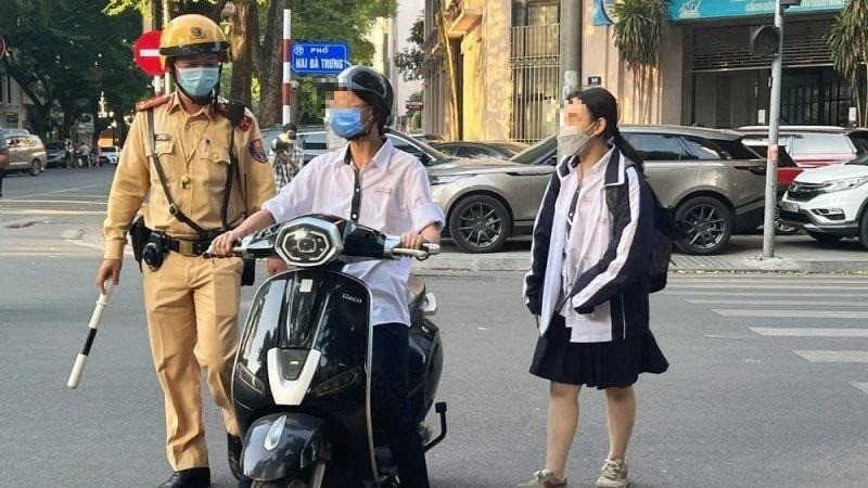 Lực lượng cảnh sát giao thông kiểm tra, xử lý học sinh vi phạm an toàn giao thông của học sinh. (Ảnh: Báo Nhân Dân)