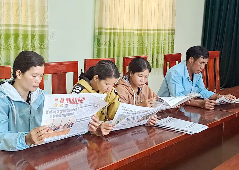 Đọc báo đầu ngày làm việc tại xã Rô Men, huyện Đam Rông, tỉnh Lâm Đồng. (Ảnh MAI VĂN BẢO) 