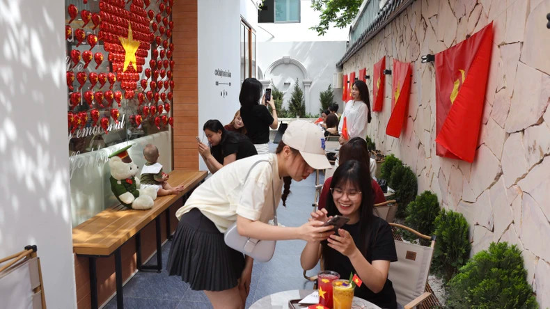 Du khách hào hứng "check-in" tại quán cà-phê ở Hà Nội. (Ảnh: nhandan.vn)