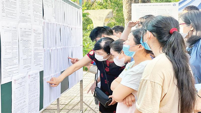 Cha mẹ và học sinh tìm hiểu thông tin nhập học lớp 10 tại Trường trung học phổ thông Yên Hòa. (Ảnh NGUYỄN HOÀI)